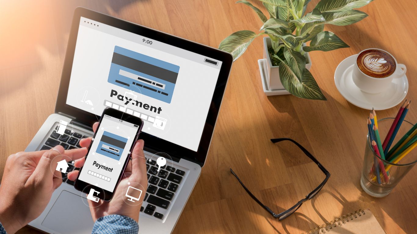 Custom Forms and Payment Systems That Convert Without Friction Person using a smartphone to complete a transaction through custom forms and payment systems on a laptop.